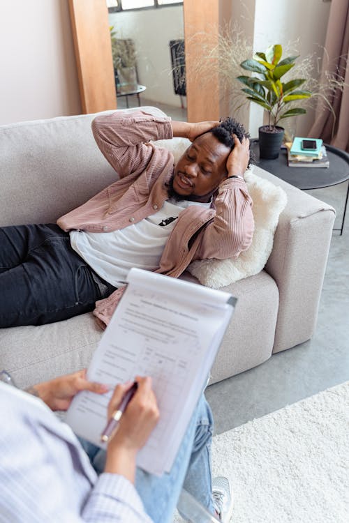 Man Lying Down on a Couch Looking Stressed