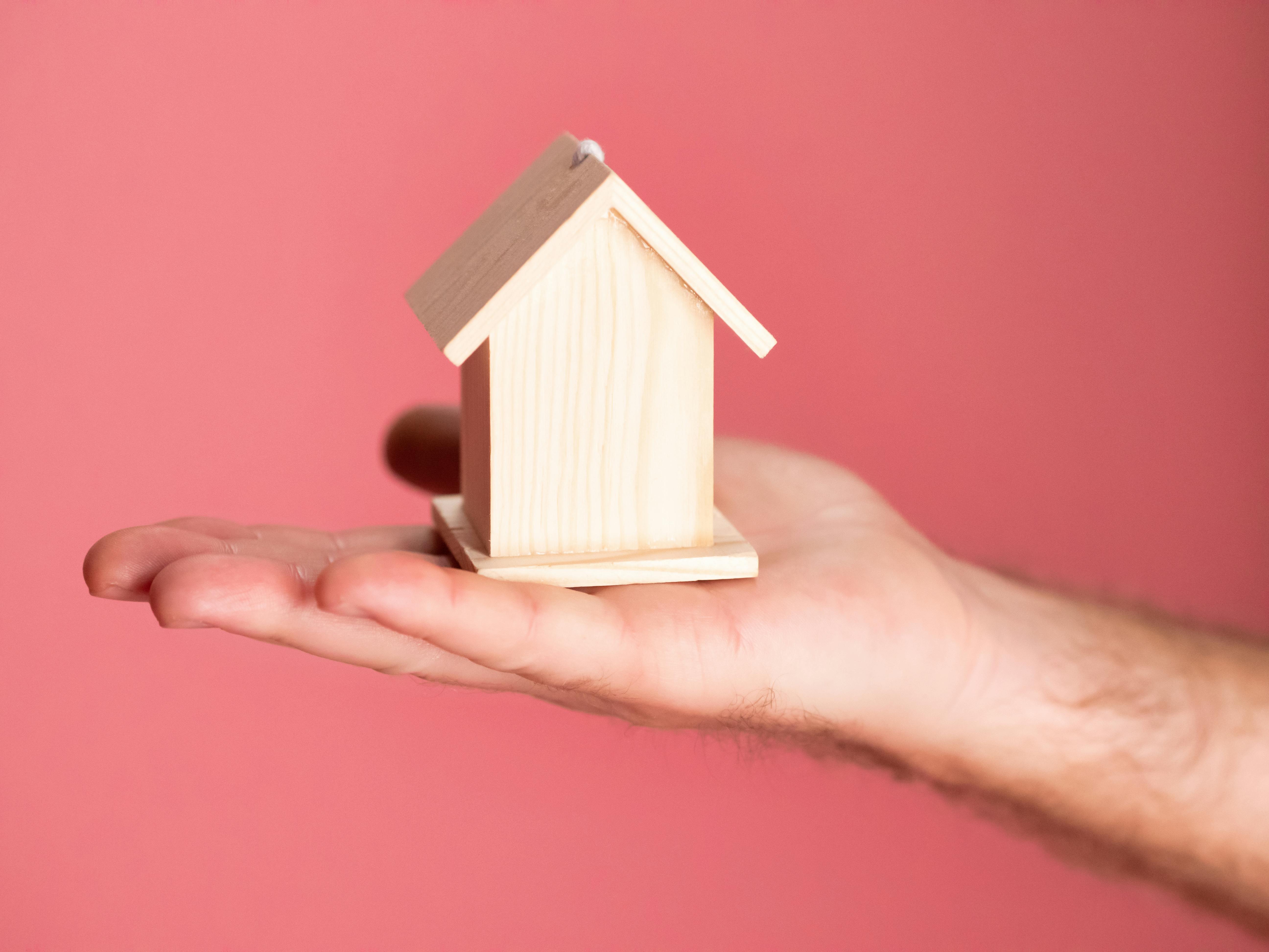 Free Person Holding Brown Miniature Wooden House  Stock Photo