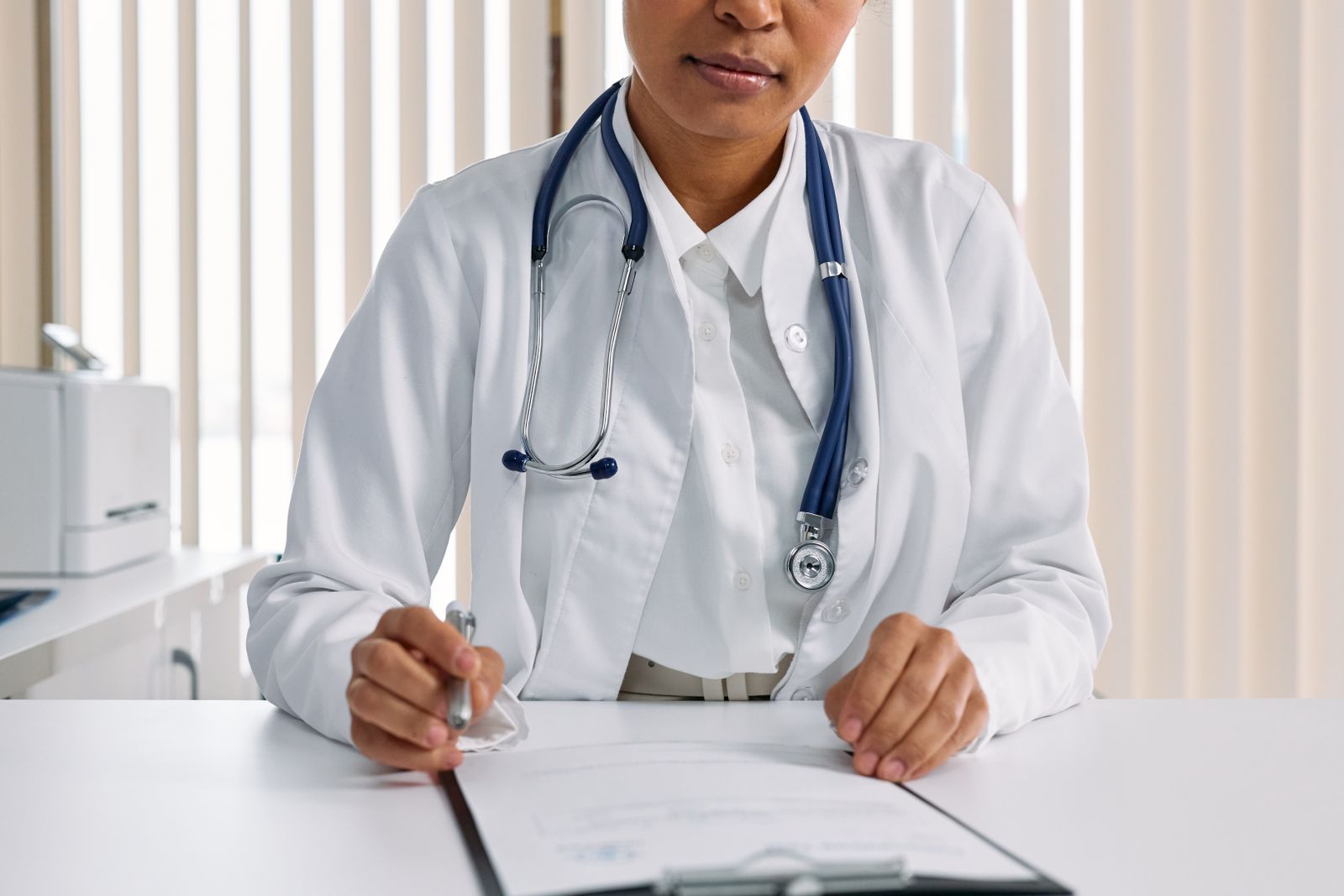 A doctor writing up notes at a desk