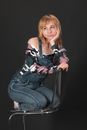 Woman in Denim Jumpsuit Posing on Top of Chair