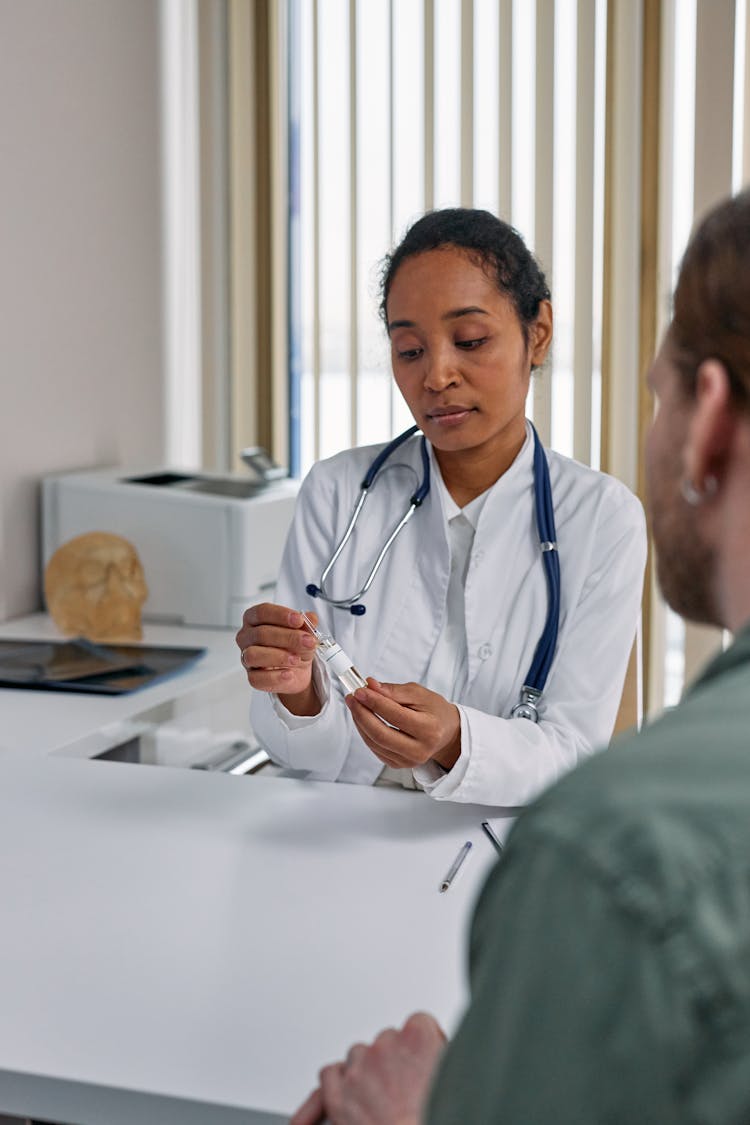 Doctor Sitting By Table With Patient