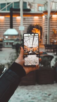 A hand holding a smartphone captures a visually appealing indoor setting with a warm ambiance.