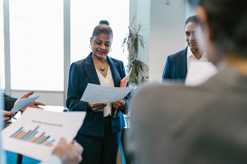 Free A group of professionals reviewing documents during a business meeting in a modern office setting. Stock Photo
