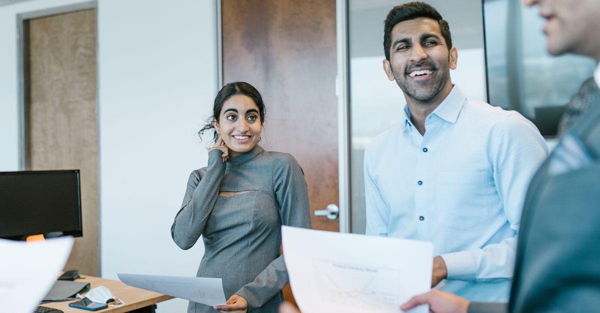 Business professionals engaged in a lively discussion during a team meeting in a modern office.