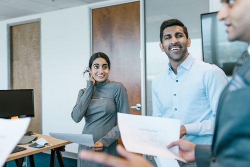 Free Business professionals engaged in a lively discussion during a team meeting in a modern office. Stock Photo