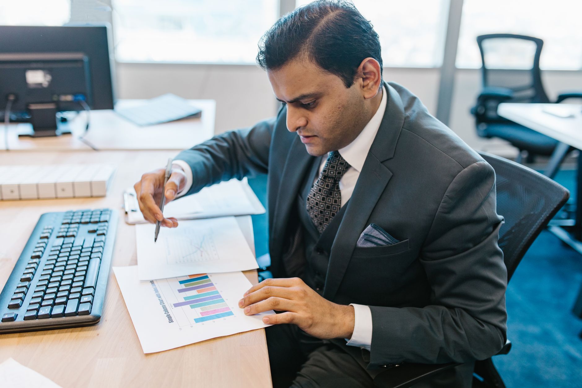 Advisor reviewing investment charts at a desk.