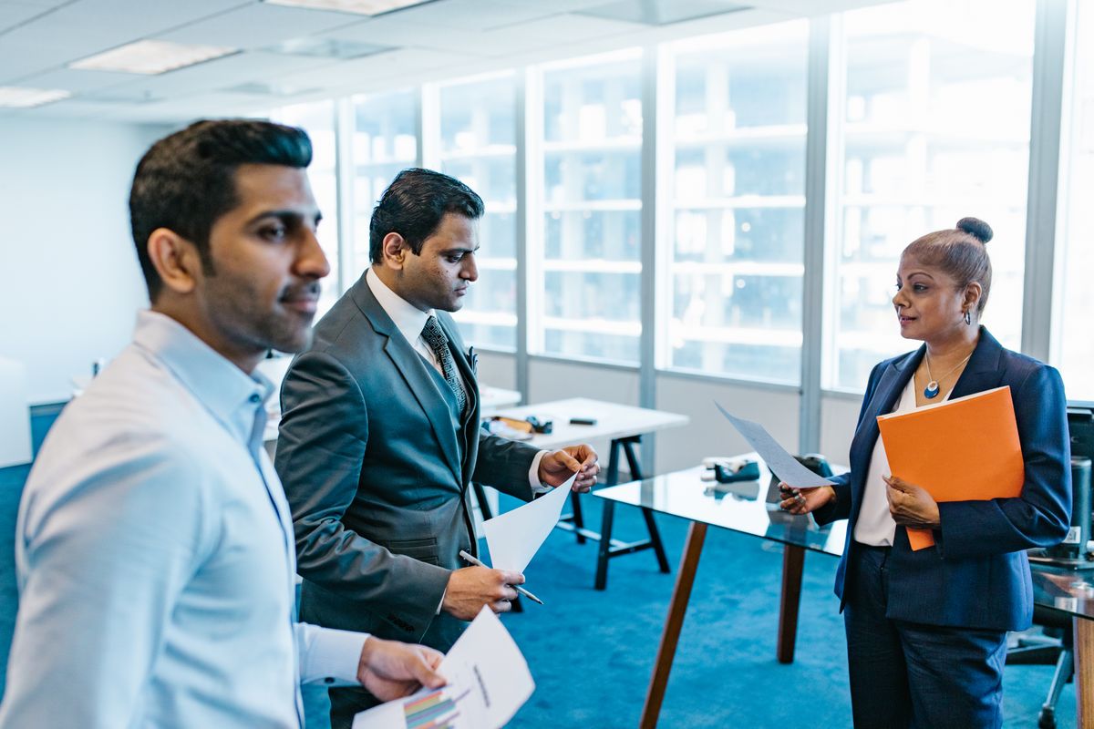 Business colleagues reviewing printed documents together in a meeting room