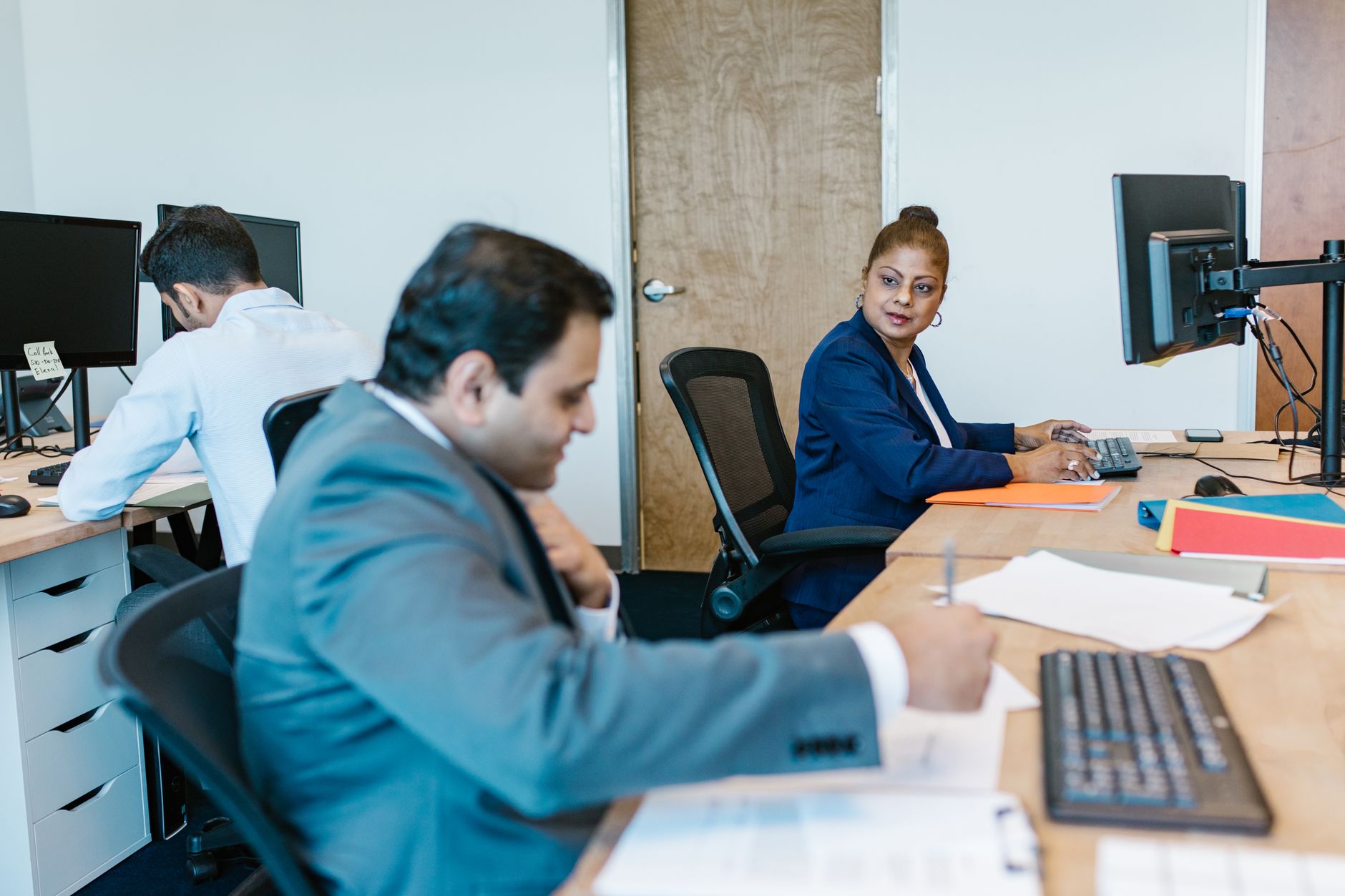 Diverse professionals collaborating in modern office setting, fostering teamwork.