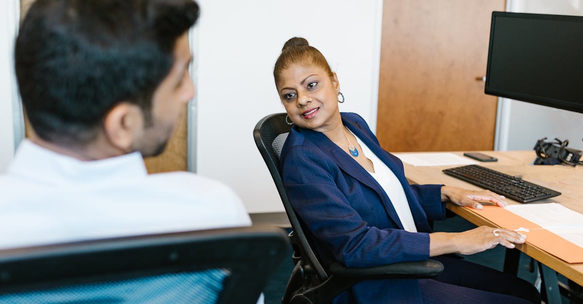 Two colleagues engaged in conversation, showcasing communication in a modern office.