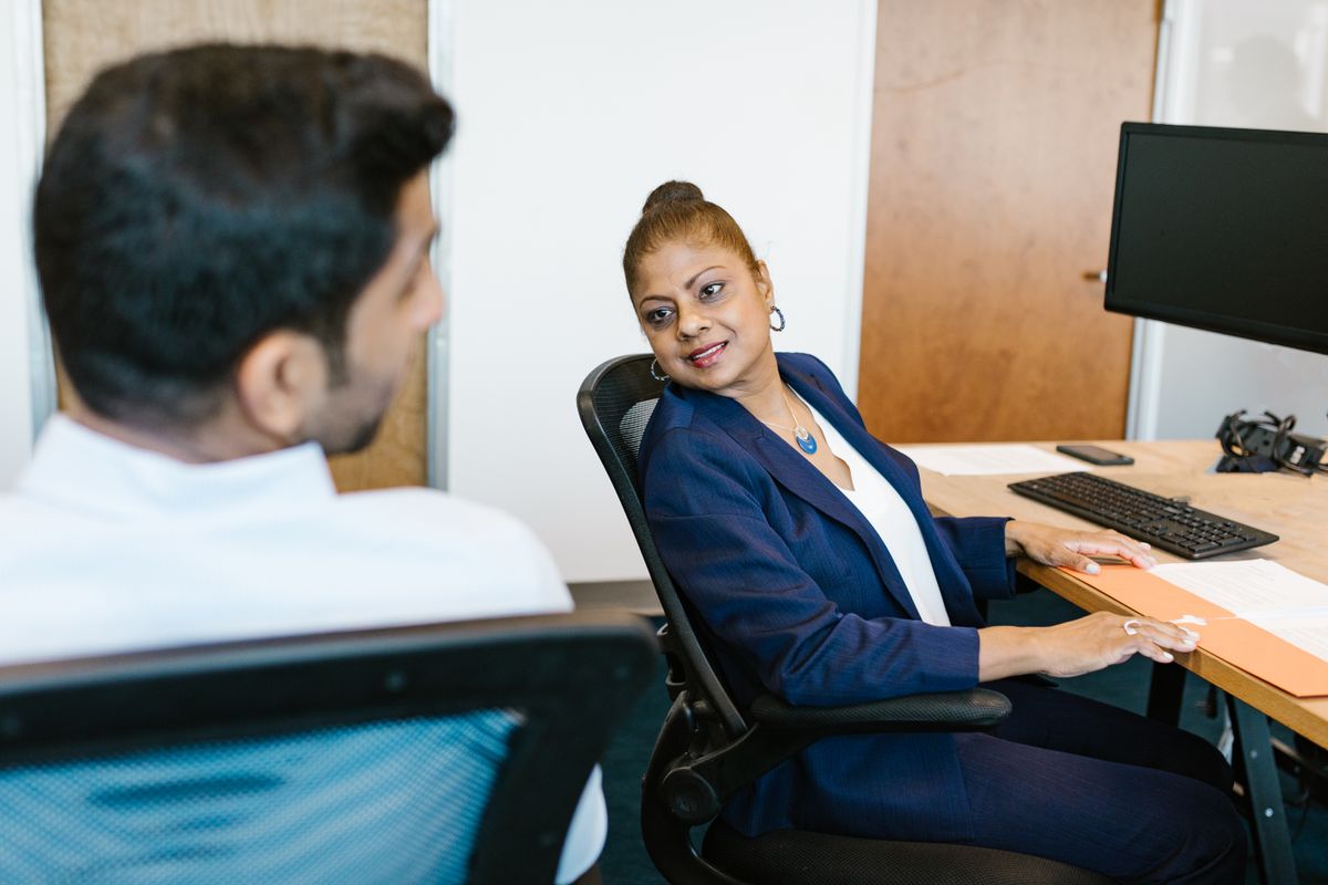 Two colleagues in conversation at a desk