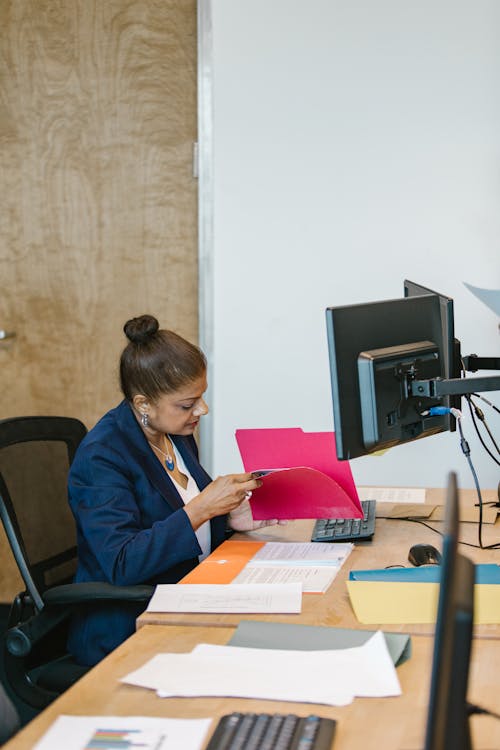 Woman in Blue Jacket Sitting on Black Office Rolling Chair