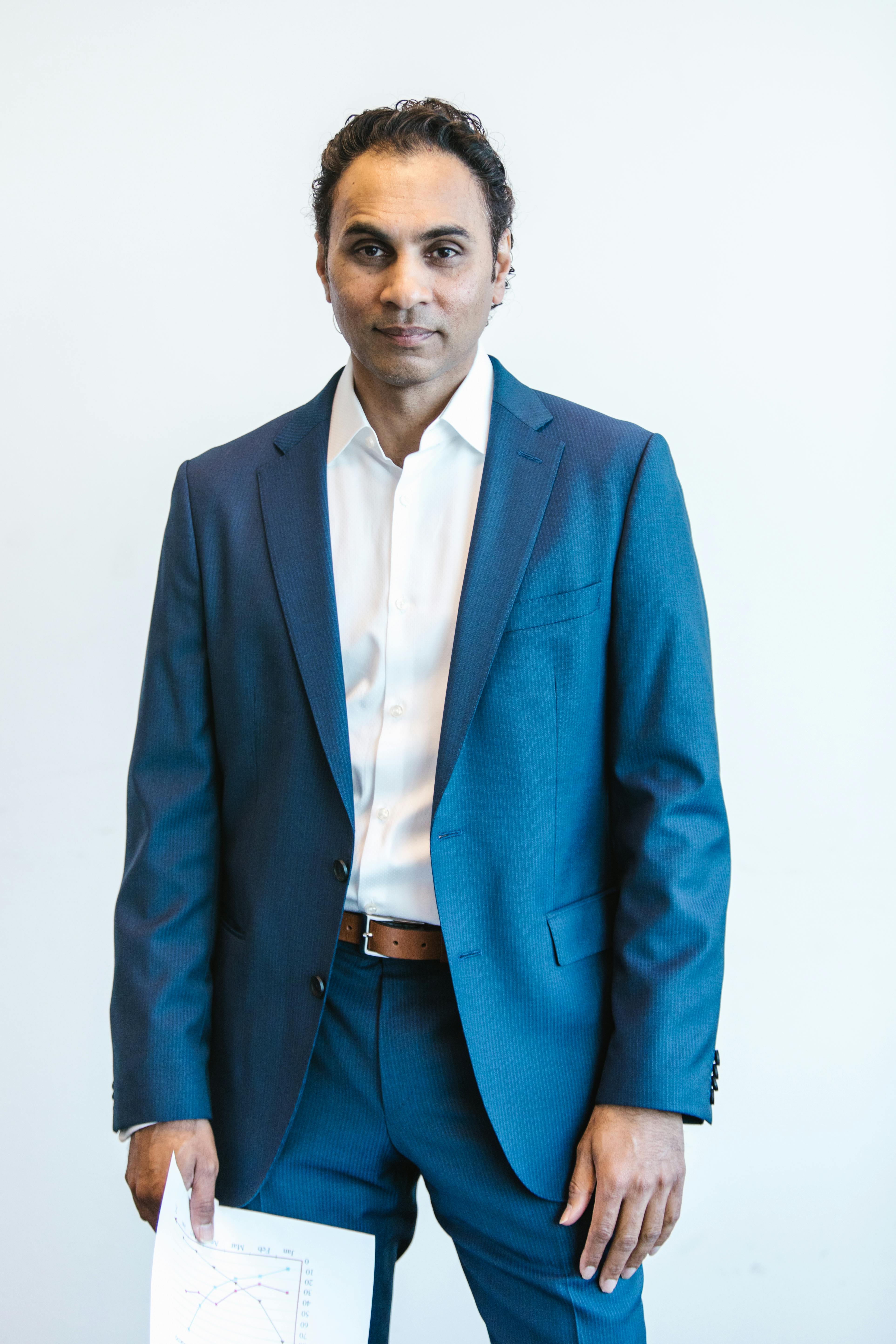 man in blue suit jacket and blue dress pants