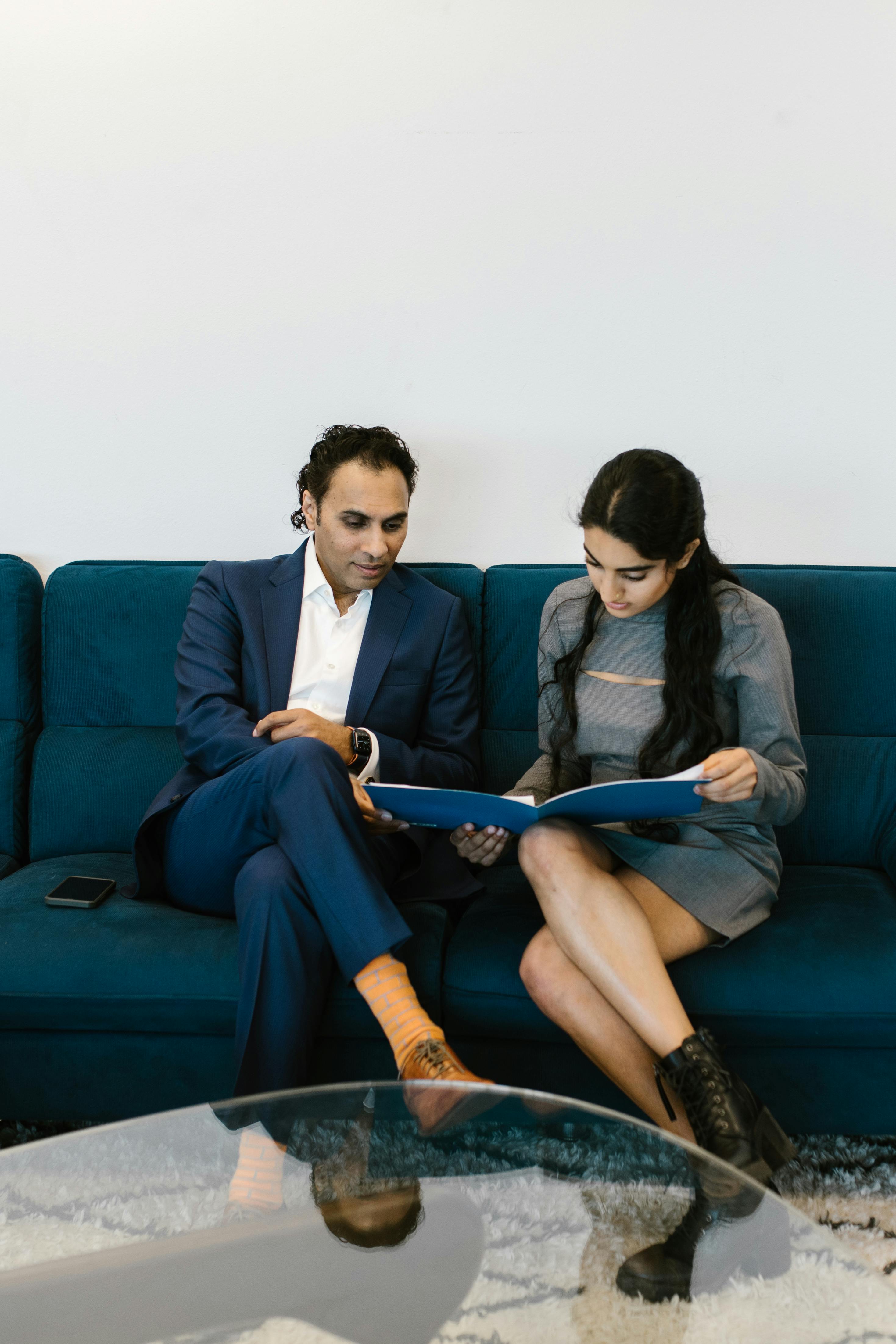 Man in Blue Suit Sitting Beside Woman in Blue Blazer