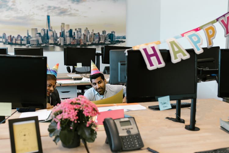 Man And Woman Hiding Behind A Desk