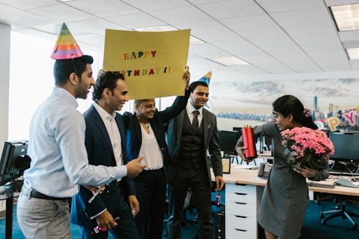 Colleagues surprise a coworker with a birthday celebration in a modern office setting.