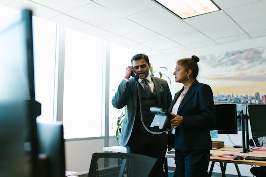 South Asian professionals discussing business in a modern office setting.