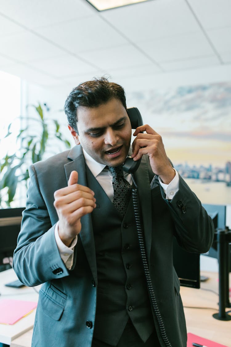 Man In Black Suit Talking On The Telephone