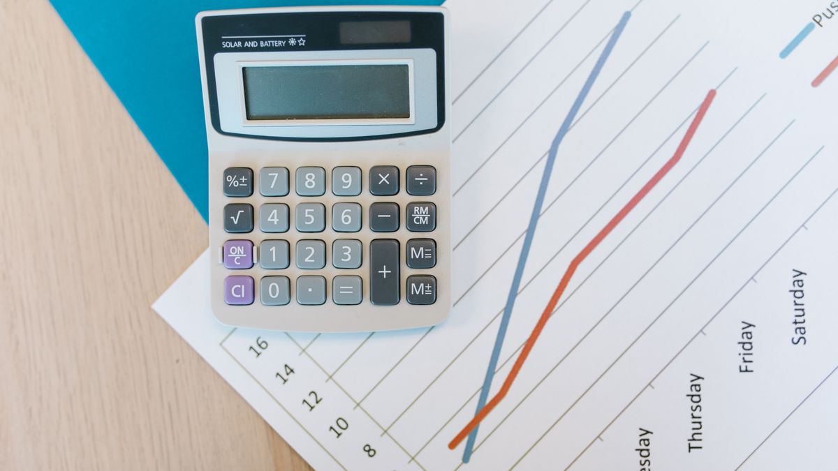 Calculadora sobre papel quadriculado em uma mesa de trabalho, representando o cálculo de reserva financeira antes de trocar de emprego