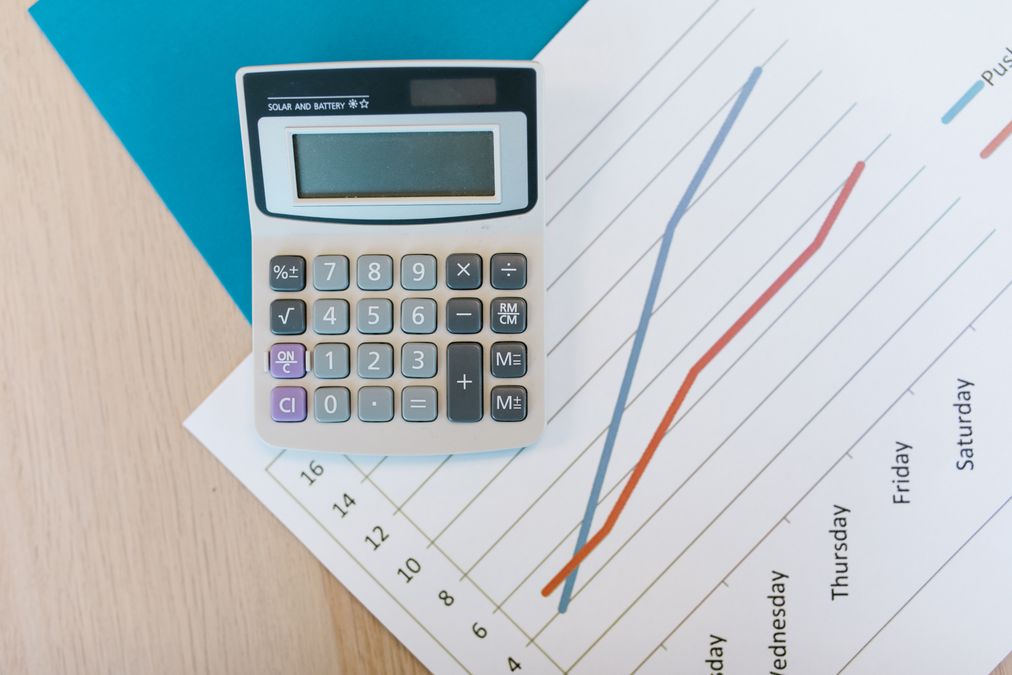 Calculadora sobre papel quadriculado em uma mesa de trabalho, representando o cálculo de reserva financeira antes de trocar de emprego