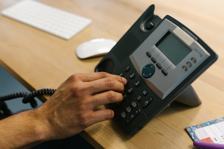 Person Dialing The Telephone