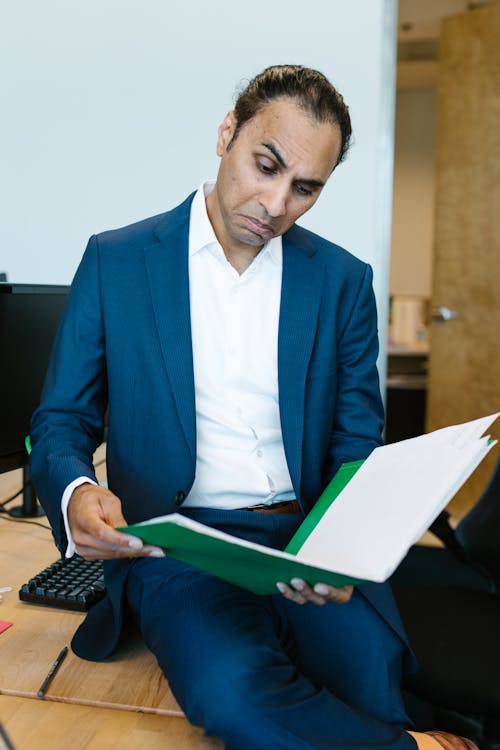 Free Man in Blue Suit Jacket Holding a Folder with Documents Stock Photo