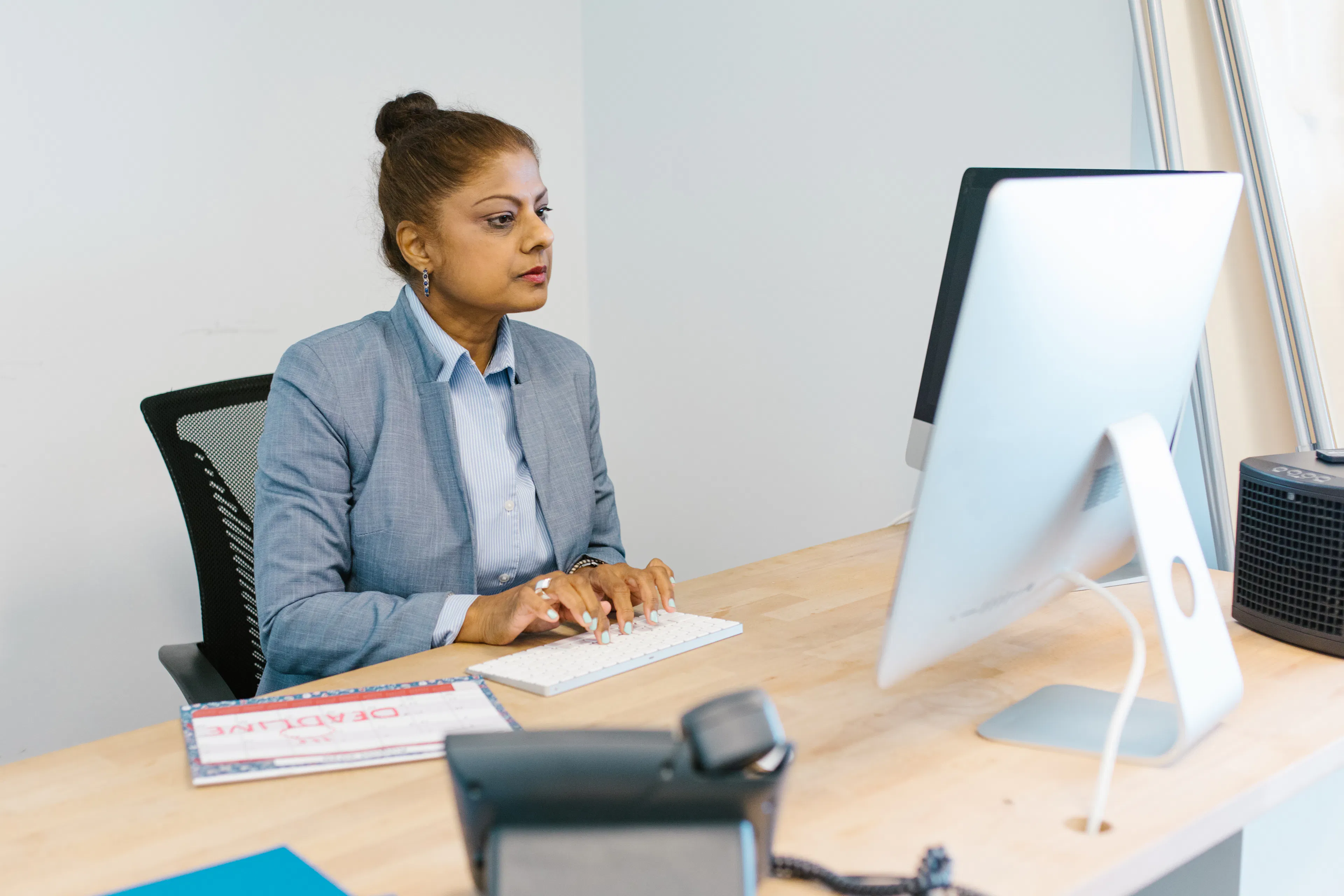 Professional woman working at a reserved seating desk, representing a flexible workspace solution in Trichy.