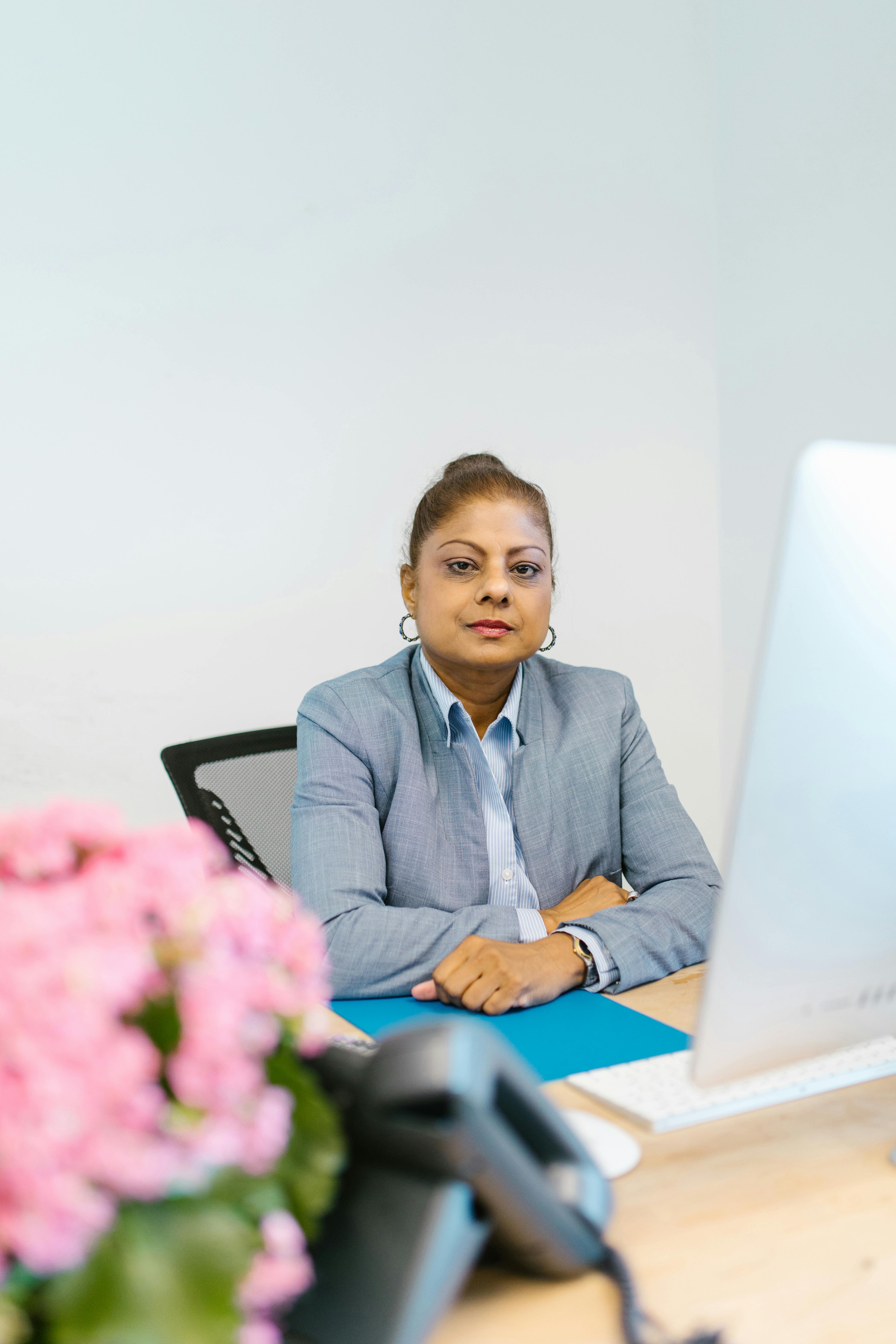 Woman in Blue Blazer Sitting on Black Chair