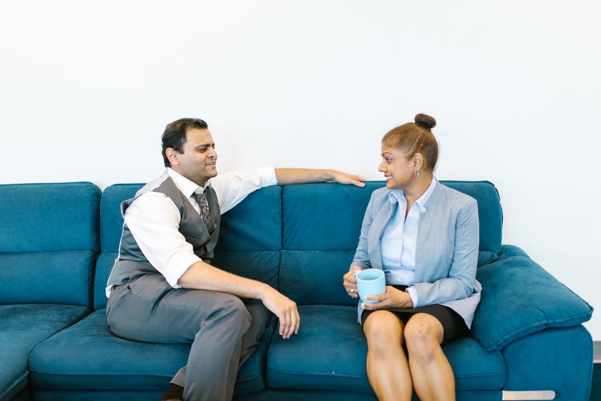 Two colleagues talking over coffee in a modern office