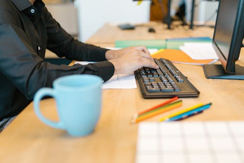 Free Person in Black Long Sleeve Shirt Typing on the Keyboard Stock Photo