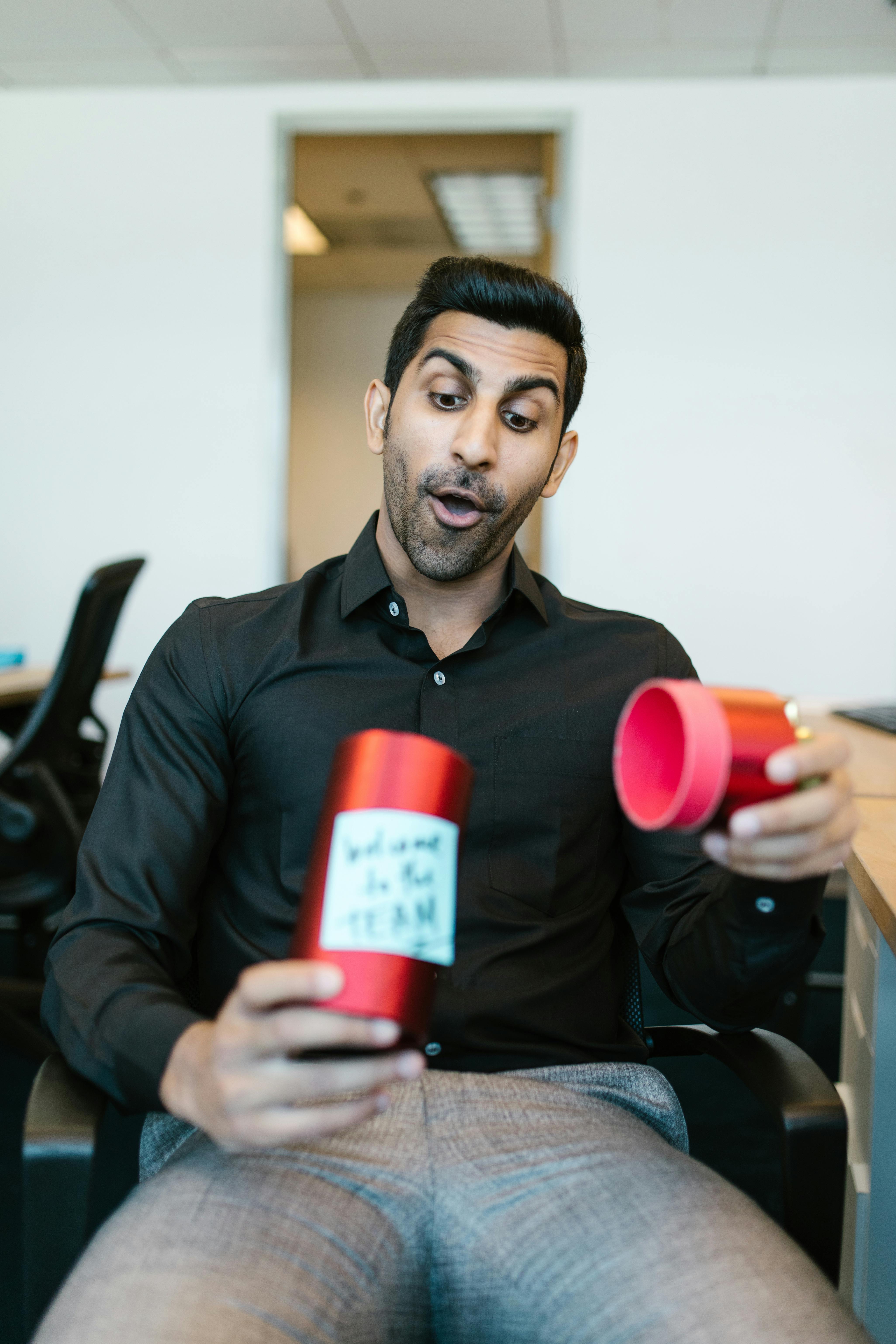Man in Black Long Sleeve Shirt Holding Red Plastic Cup
