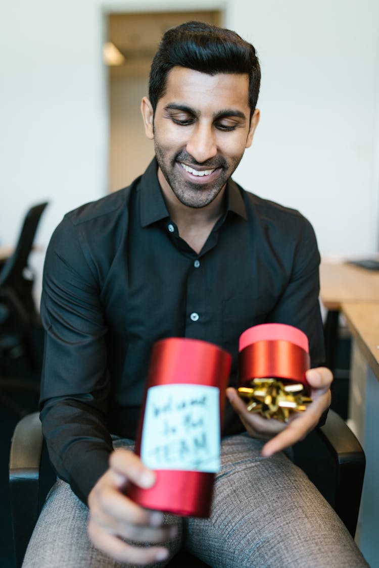 Man In Black Dress Shirt Holding A Welcome Gift