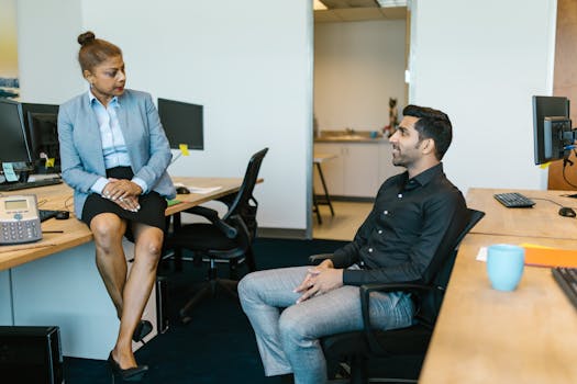 A professional discussion between colleagues in a modern office setting, fostering teamwork.