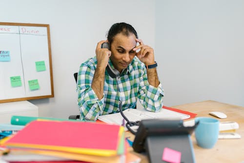 Man Wearing a Plaid Top Talking on the Phone