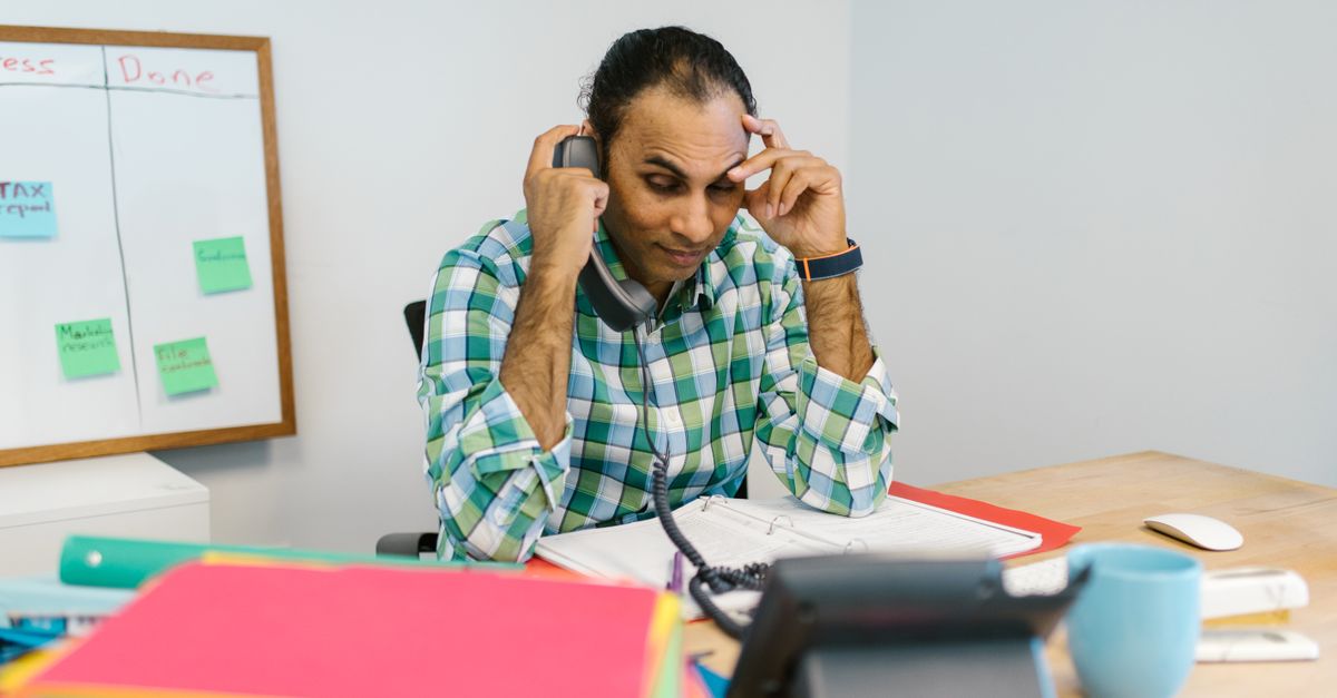 Profesional gestionando una situación complicada al teléfono en la oficina