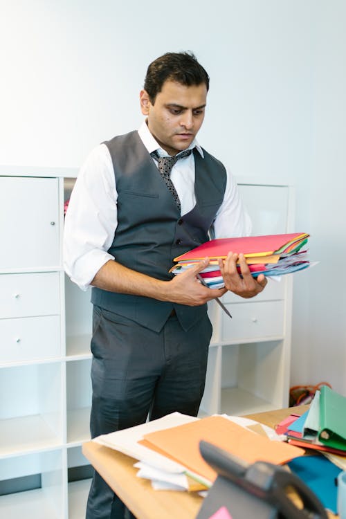 Man Wearing Waistcoat Carrying Folders