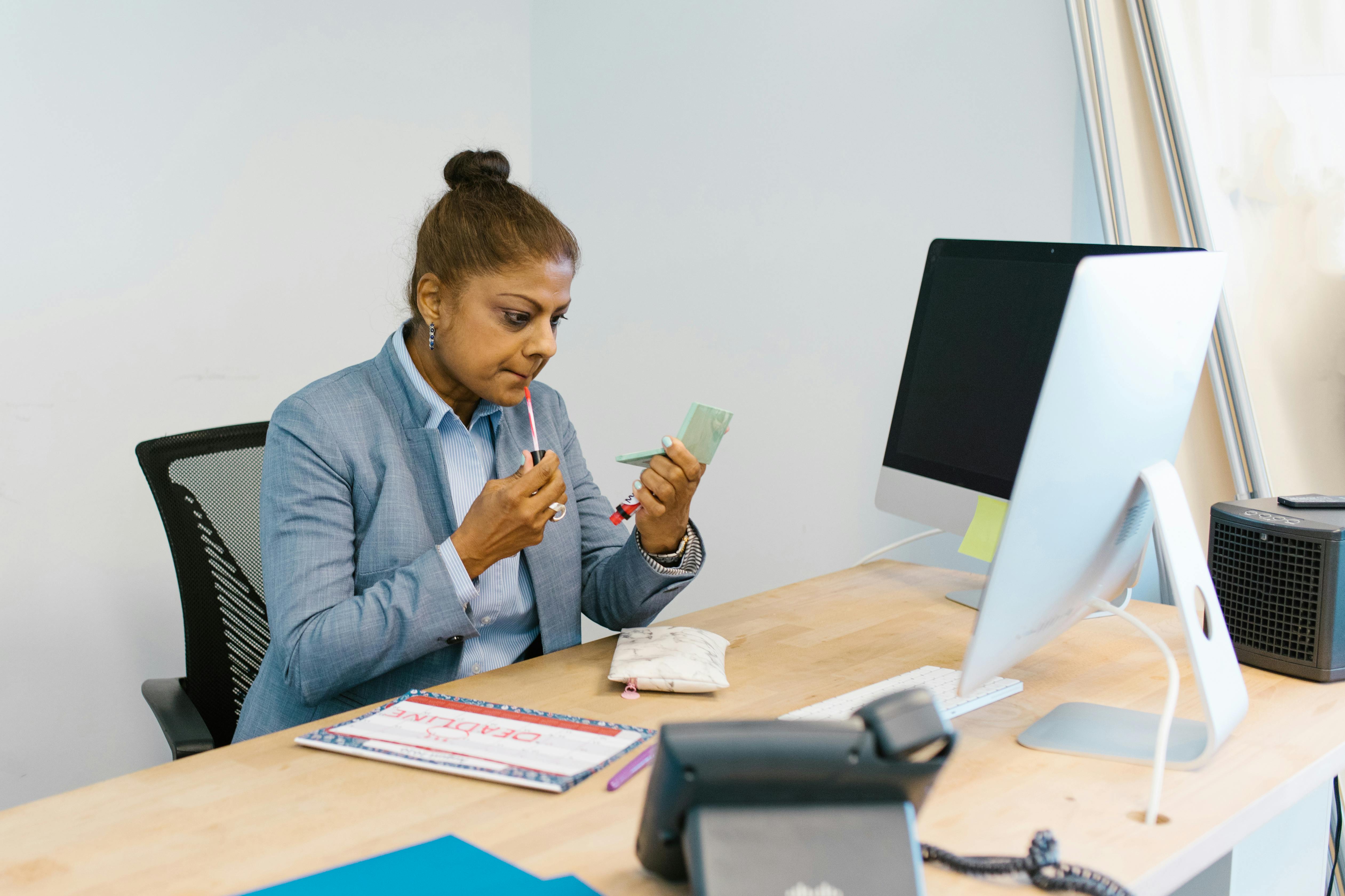 Woman in Gray Blazer Putting on Make Up