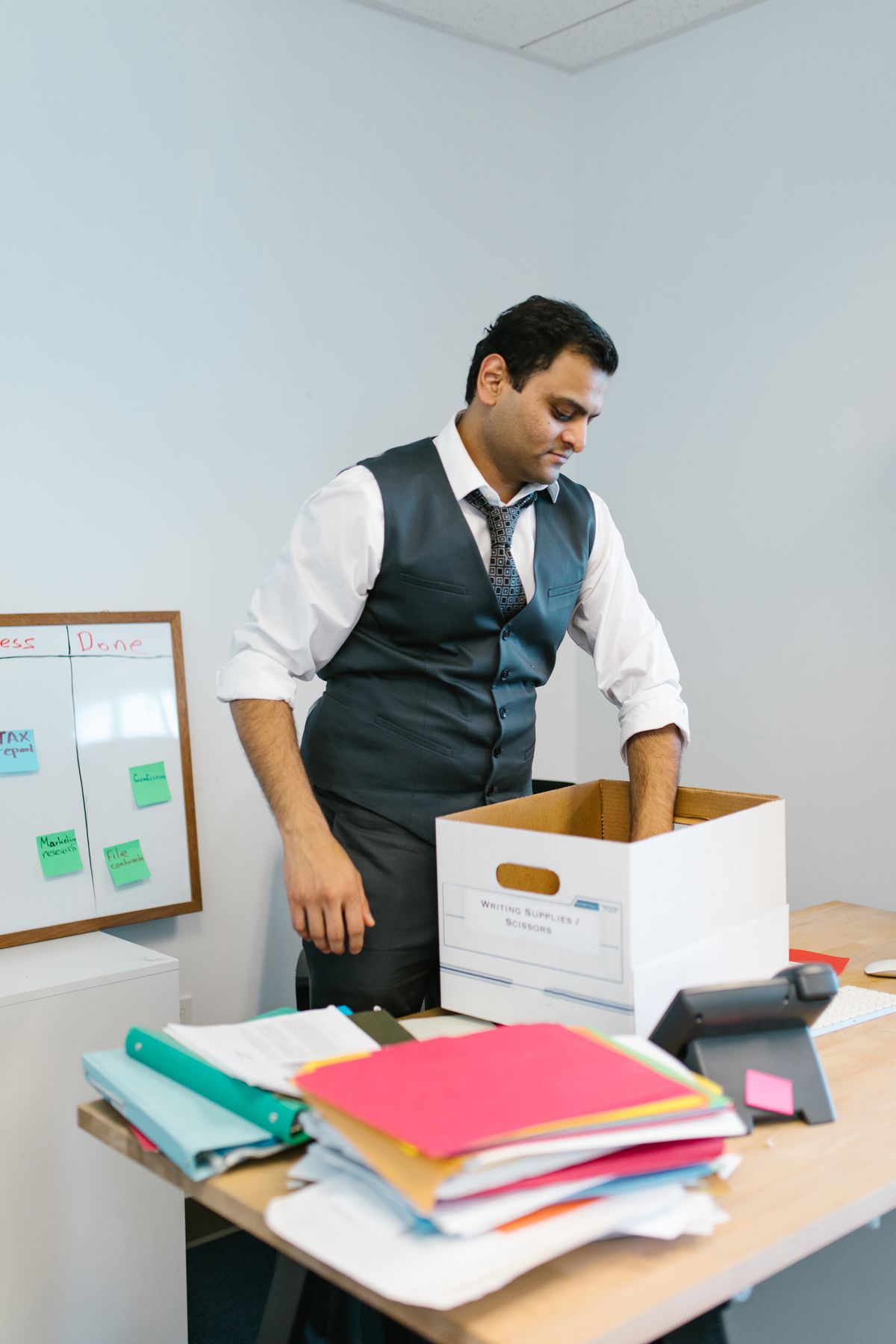 Professional man packing his belongings at an office desk before leaving work