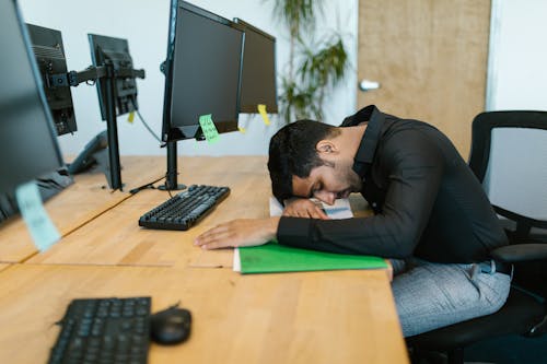 Man in Black Long Sleeve Shirt Sitting on Chair in Front of Computer