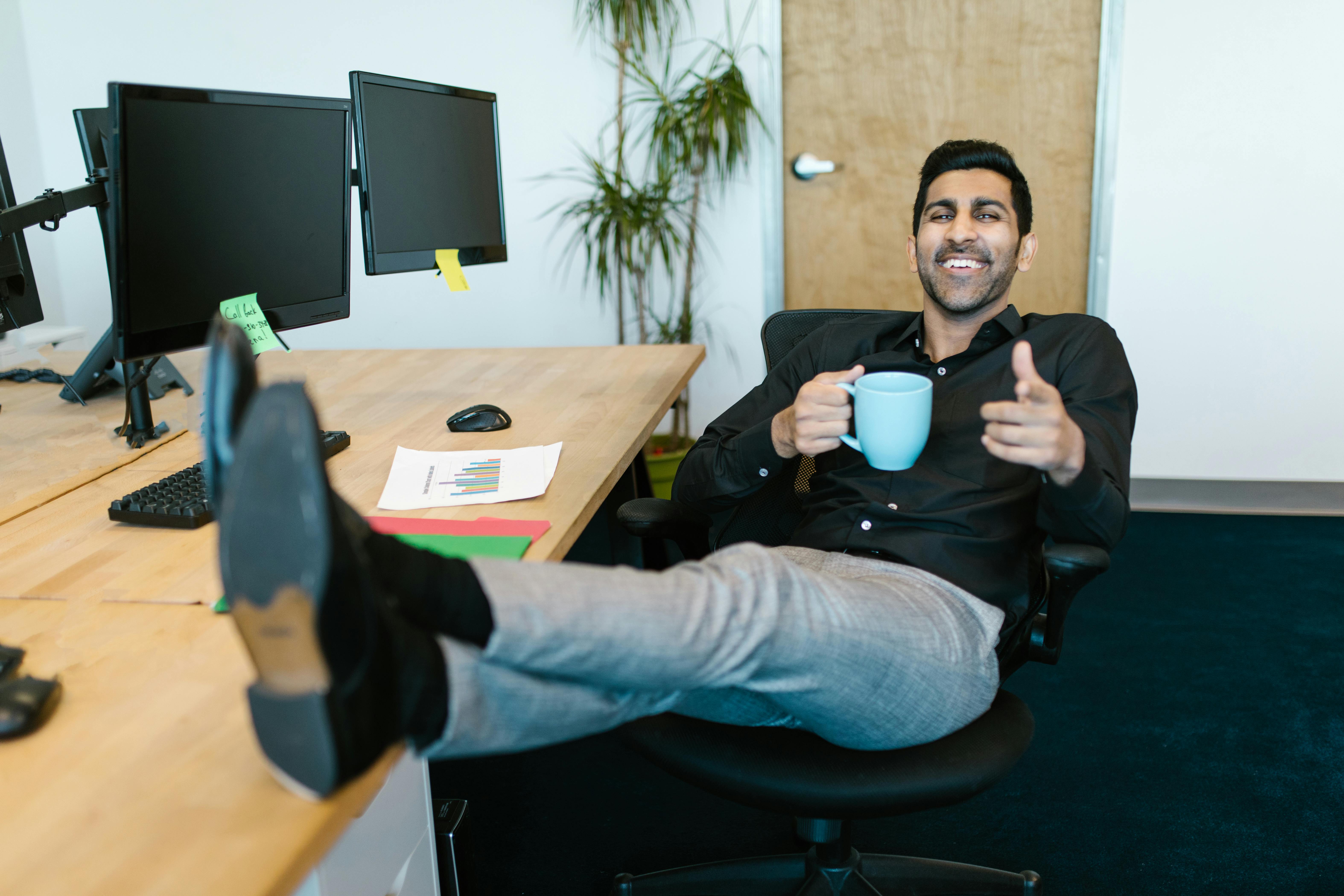 Man in Black Long Sleeve Shirt Holding a Ceramic Mug