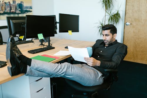 Man in Black Long Sleeve Shirt Sitting on Black Swivel Chair