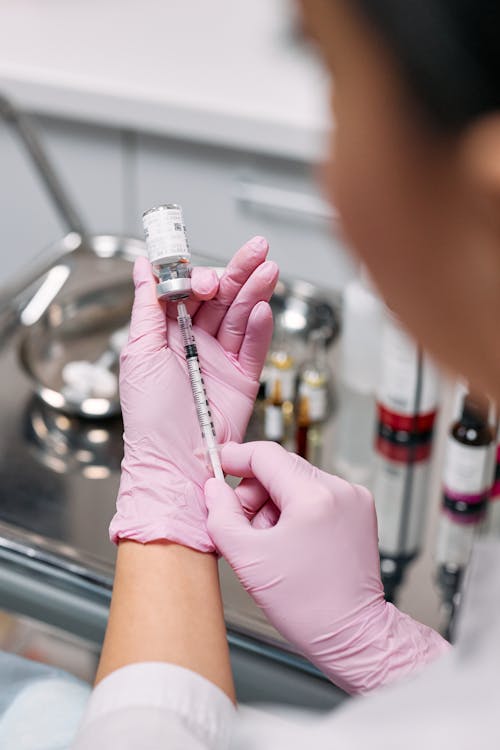 Free Doctor Inserting Syringe on an Ampoule  Stock Photo