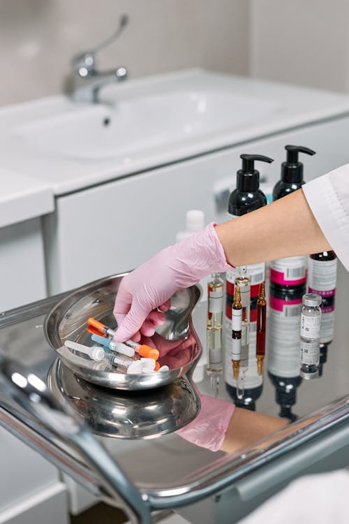 Person Holding Clear Glass Jar With Orange Liquid