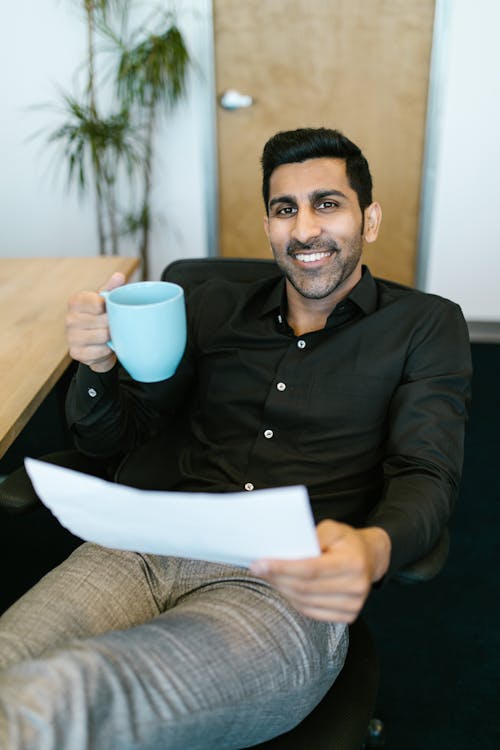 Man in Black Button Up Long Sleeve Shirt Sitting on a Chair