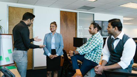 A diverse group of colleagues engaged in a collaborative meeting in a modern office setting.