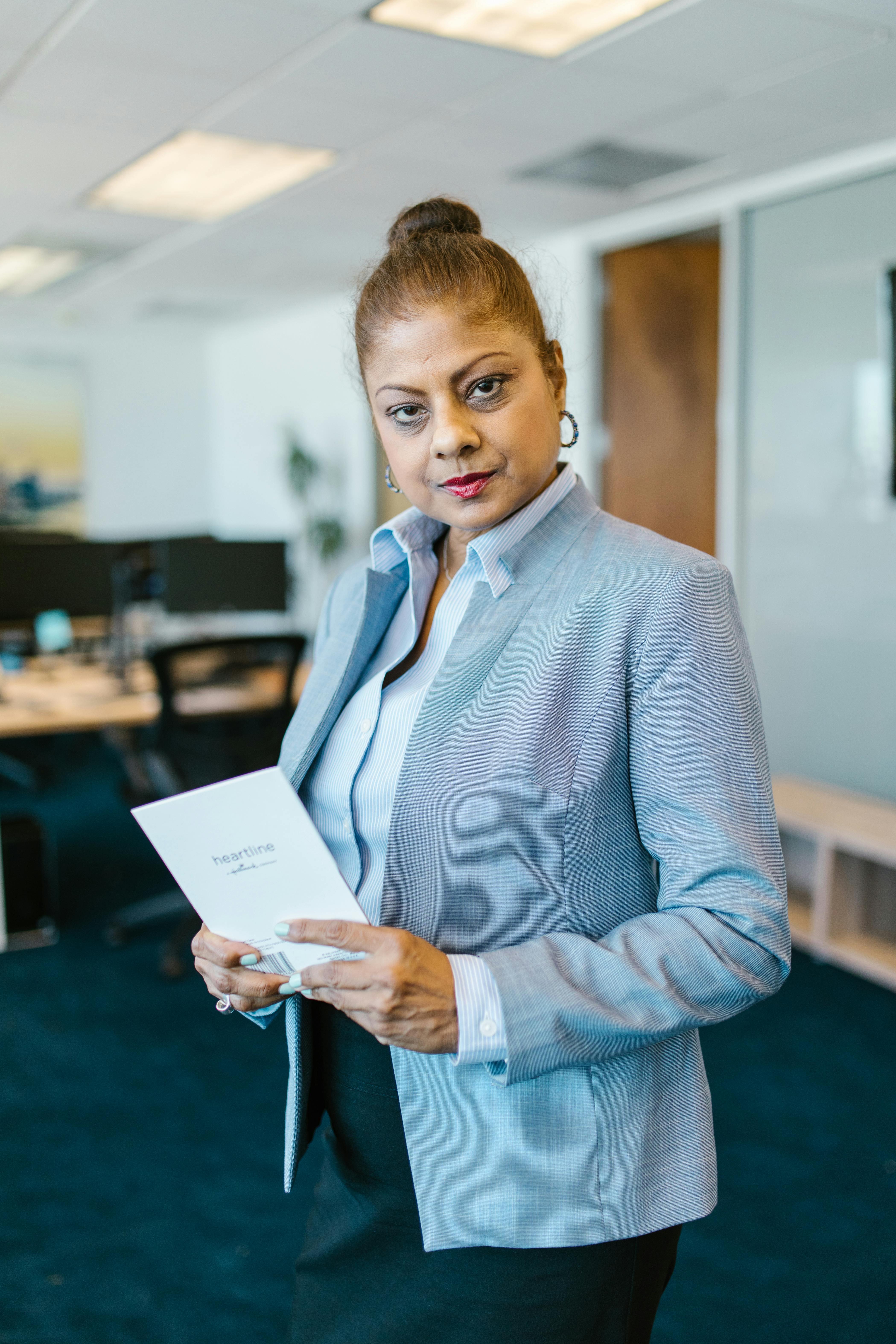 Woman Wearing a Blazer Holding White Paper