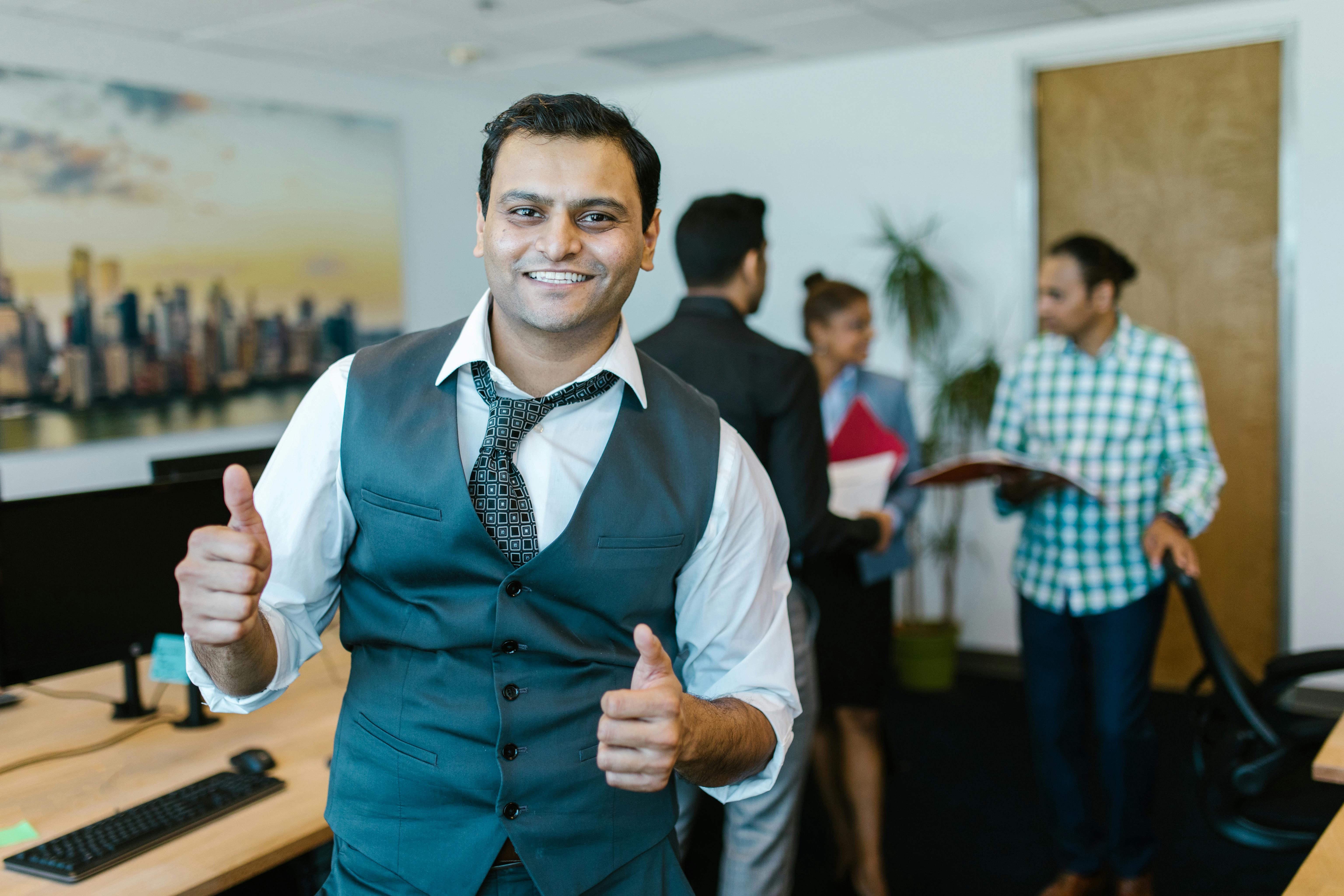 man wearing a waistcoat doing a thumbs up sign