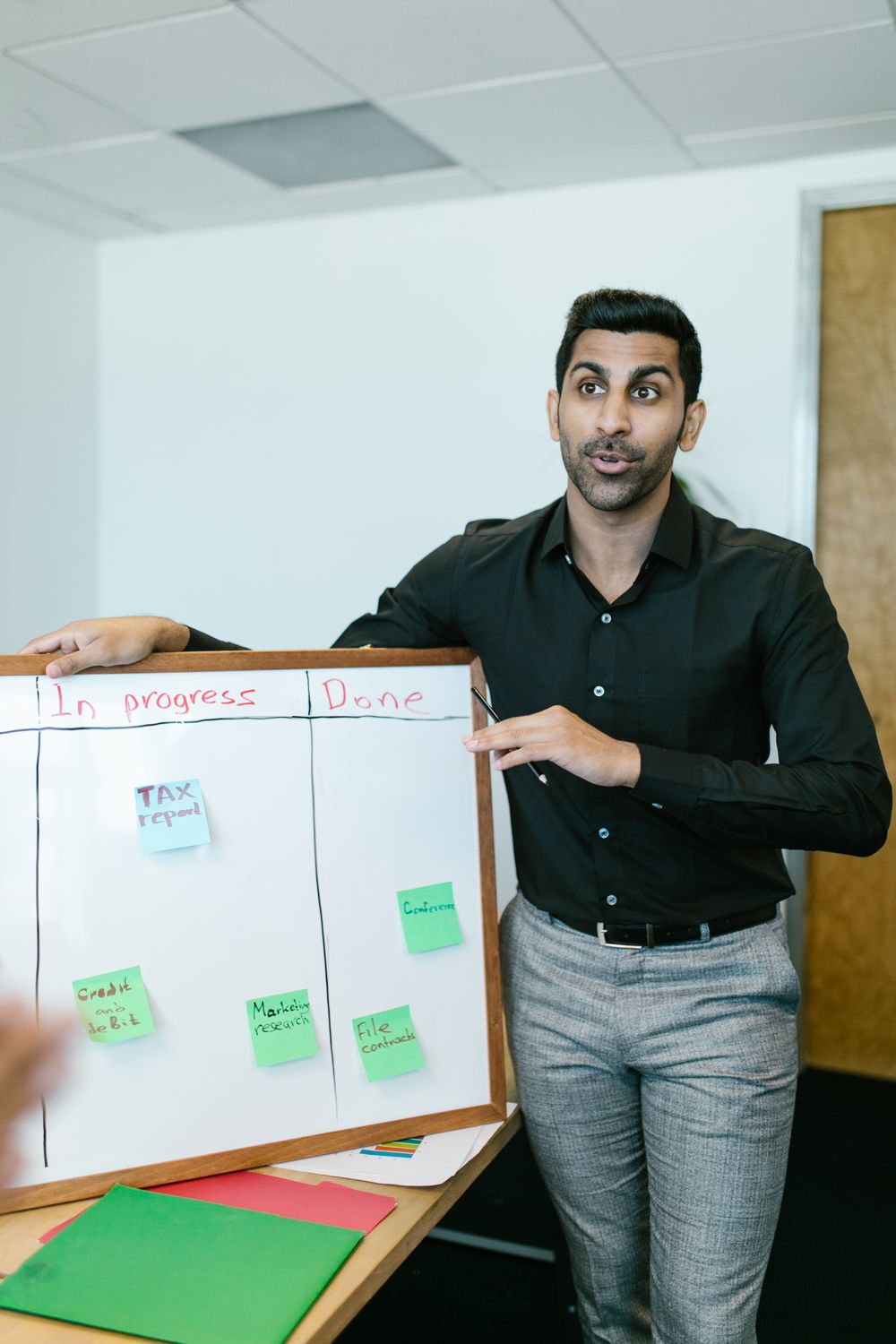 Indian professional presenting a plan on a whiteboard
