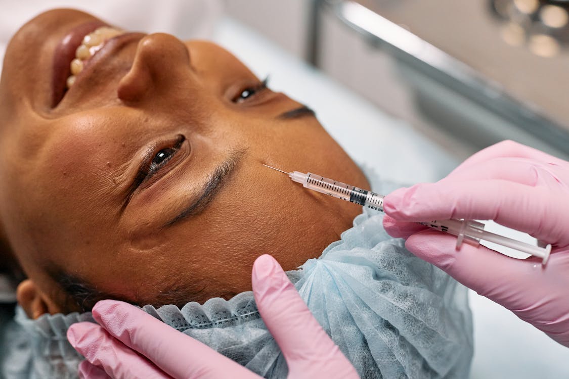 Free Woman Getting a Forehead Botox Stock Photo first medical spa visit