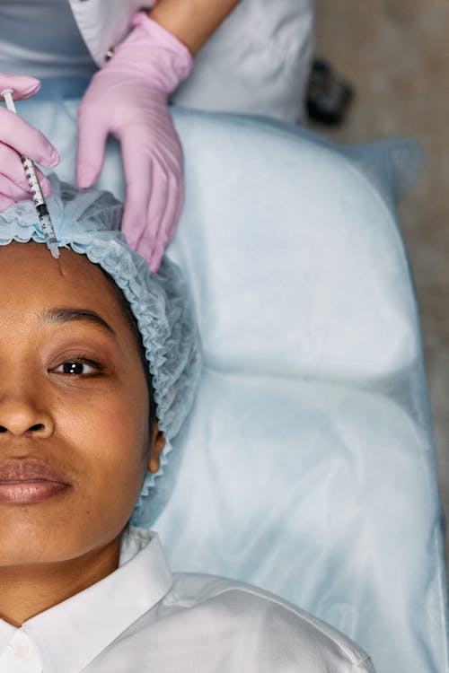Woman Lying Down Receives Forehead Botox