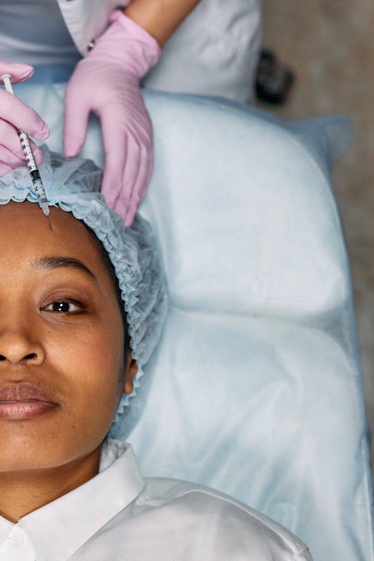 Woman Lying Down Receives Forehead Botox